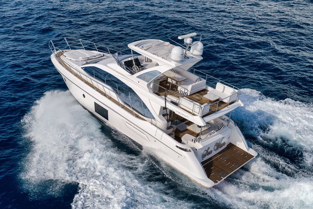 Flybridge motor yacht cruising with a wake astern